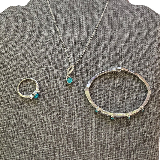 Set of silver jewelry with blue stones on a textured gray surface