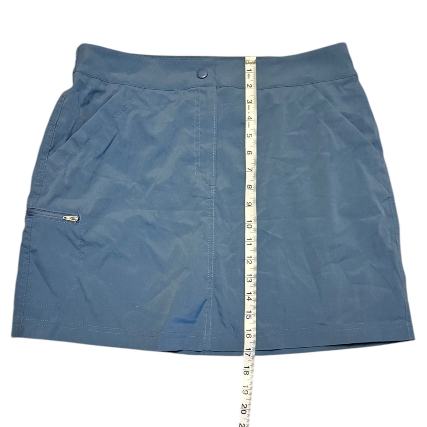Blue skort with a measuring tape for size reference on a white background