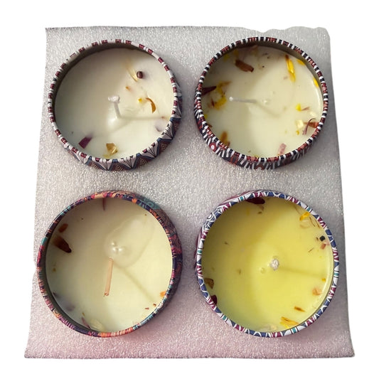 Four small candles in decorative holders on a textured surface