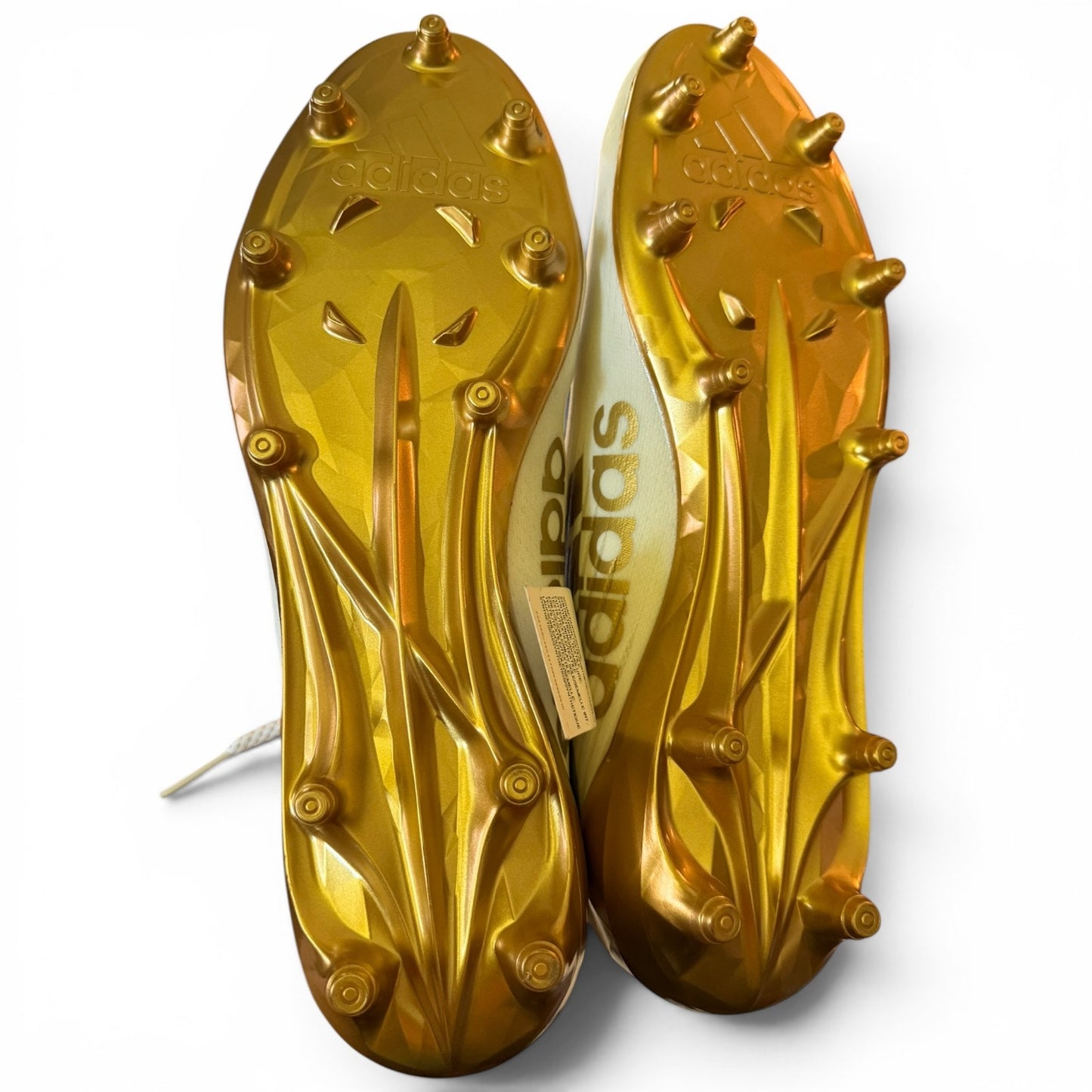 Gold Adidas soccer cleats on a white background