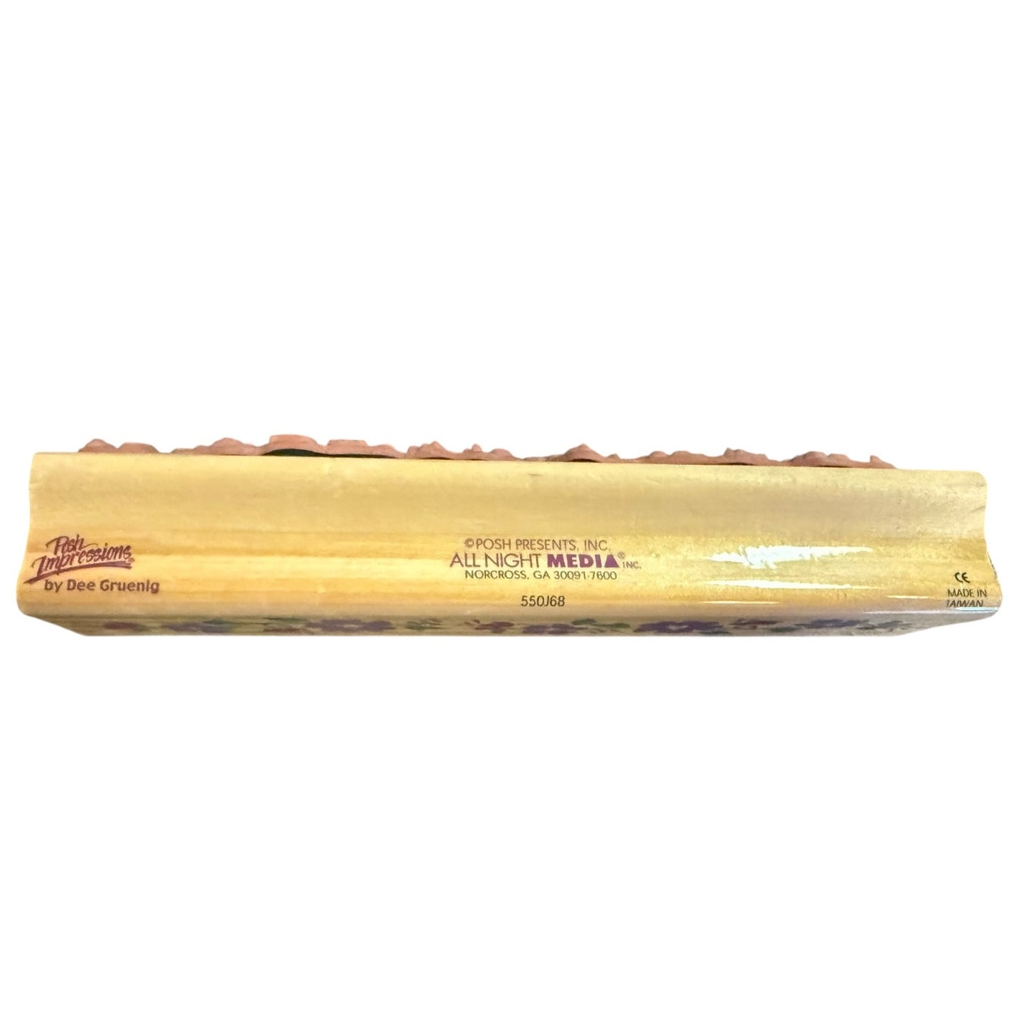 Side view of a wood block for a rubber stamp with a brand name on a white back ground.
