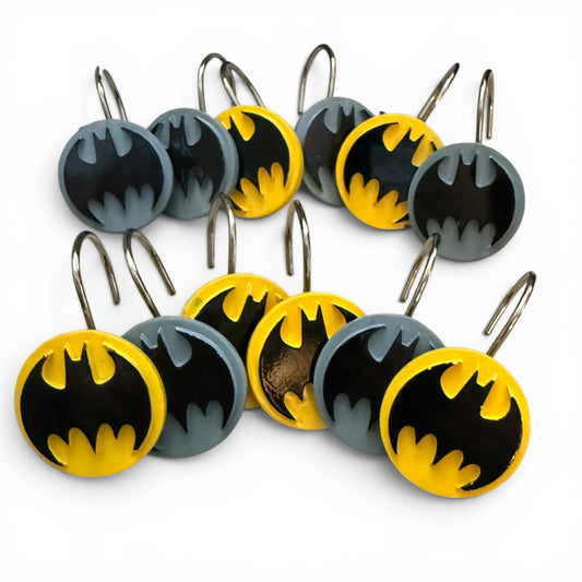 Bat-shaped shower curtain hooks with yellow and black symbols on a white background