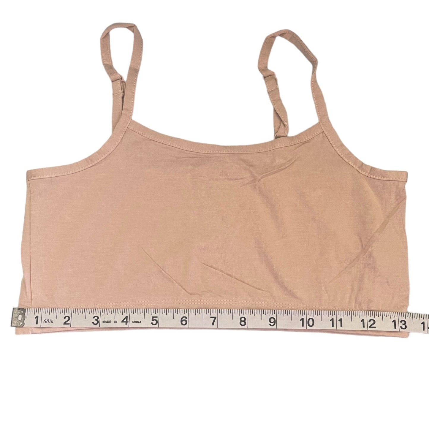 A beige camisole tank top with thin shoulder straps, shown flat against a white background with a measuring tape along the bottom hem to indicate size.