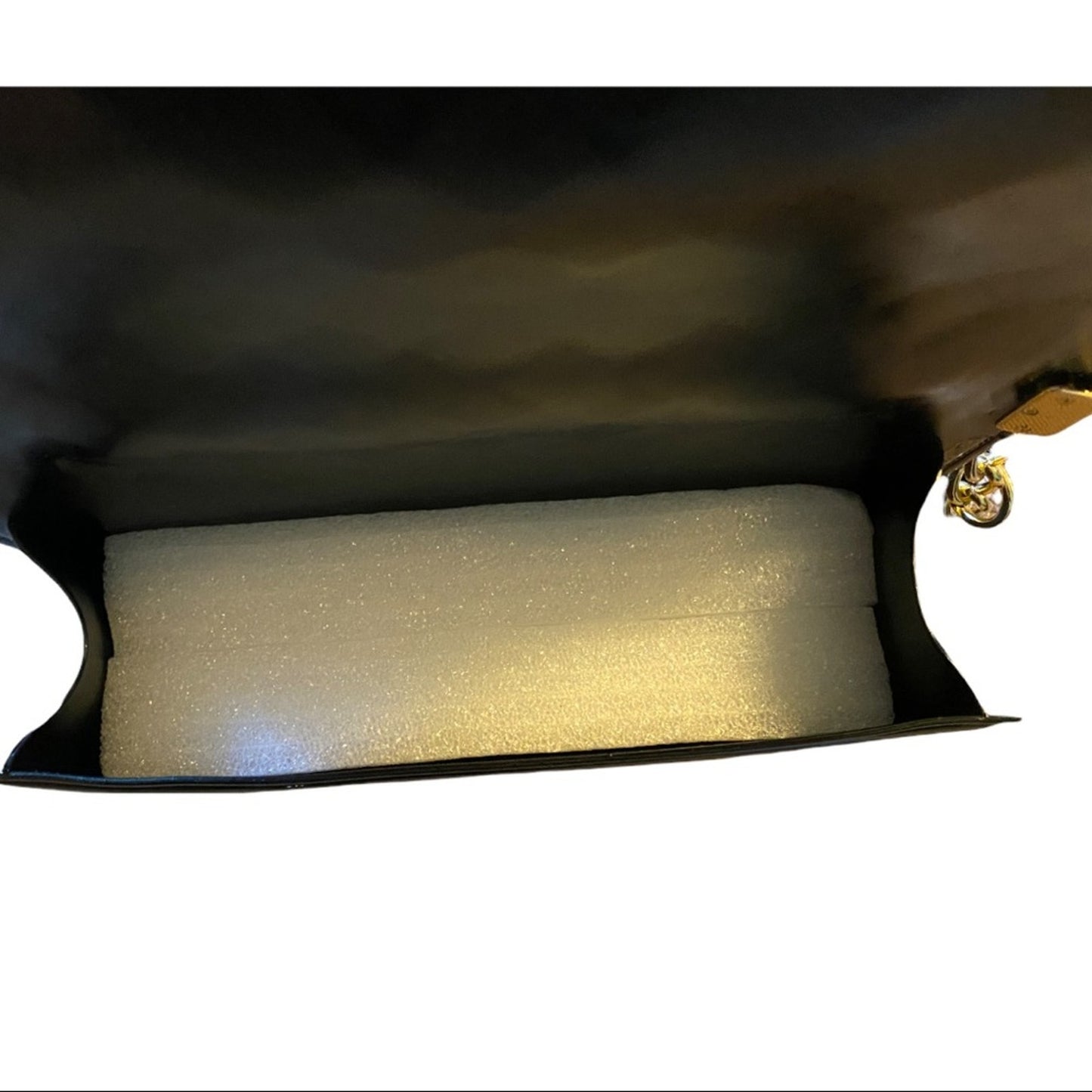 Foam block inside interior of black purse on a white background
