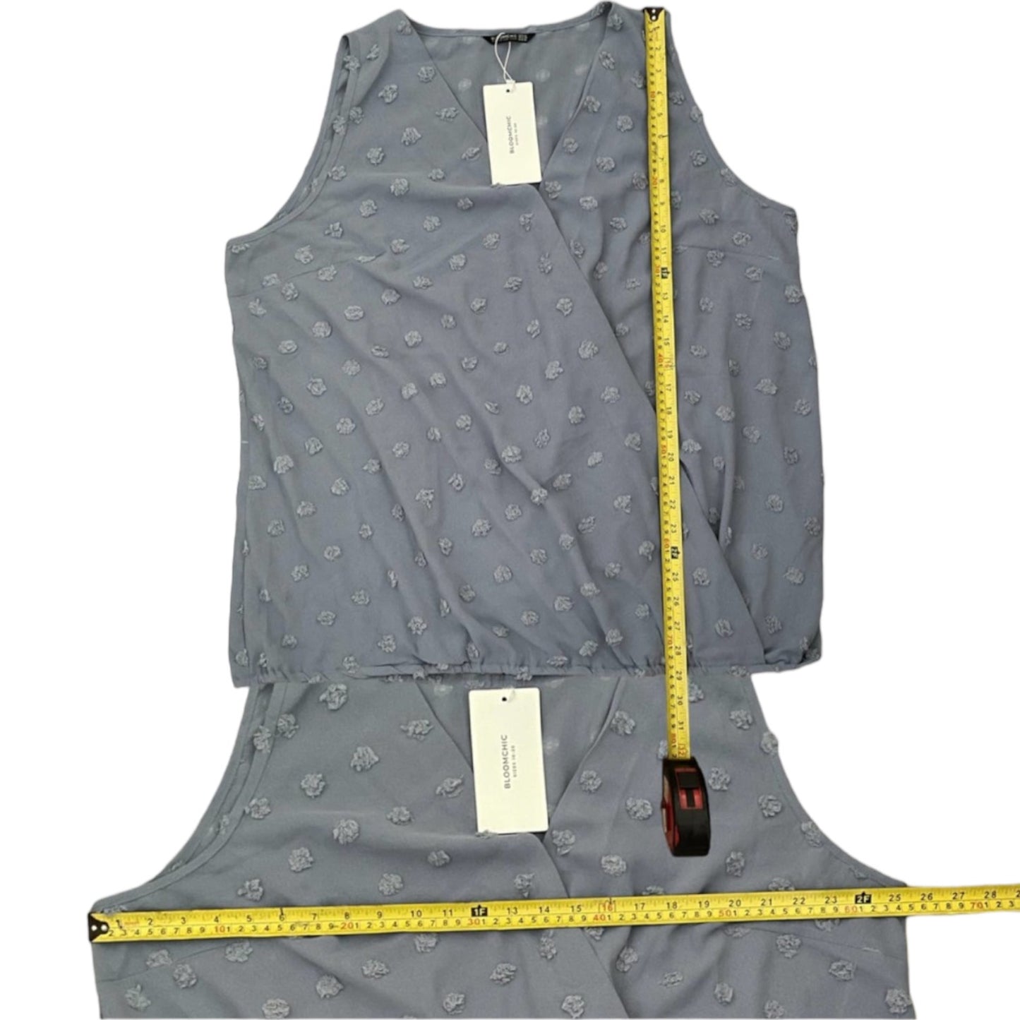 Blue sleeveless top with a measuring tape on a white background
