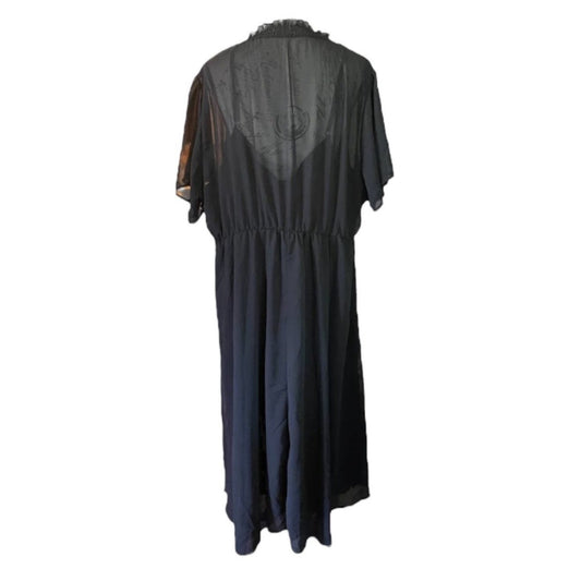 A black maxi dress with a sheer mesh overlay on the back and short sleeves, shown from the back against a plain white background.