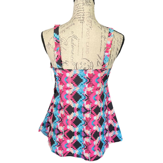 A sleeveless swimwear top with a vibrant pink, black, and blue geometric ikat pattern, displayed on a beige fabric dress form mannequin against a white background.
