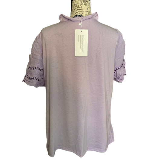 A light purple short-sleeve top displayed on a mannequin torso against a white background, featuring eyelet lace detailing on the sleeves and a hangtag on the back.