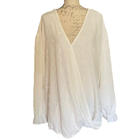 White polka dot long-sleeve top on a mannequin with a white background
