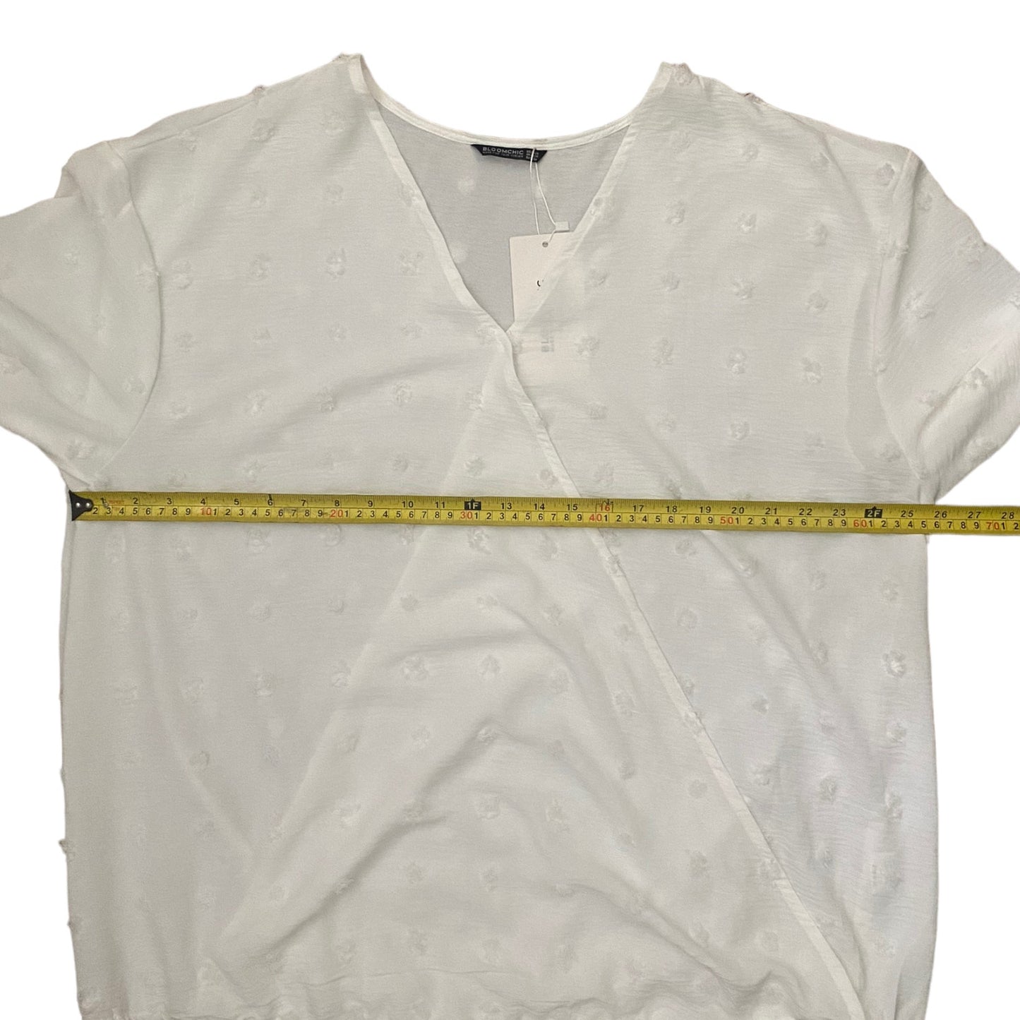 White blouse with a measuring tape across it on a white background