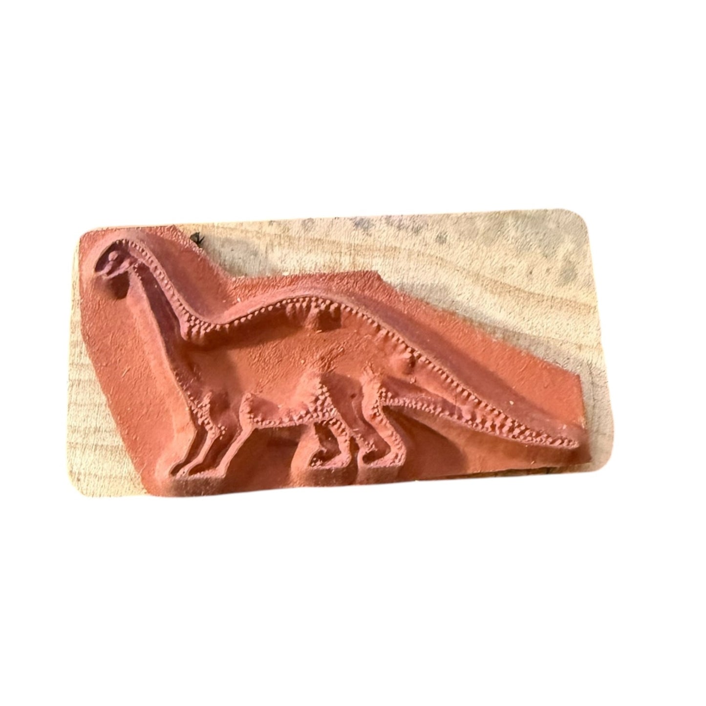 Rubber stamp with dinosaur design on a wooden block