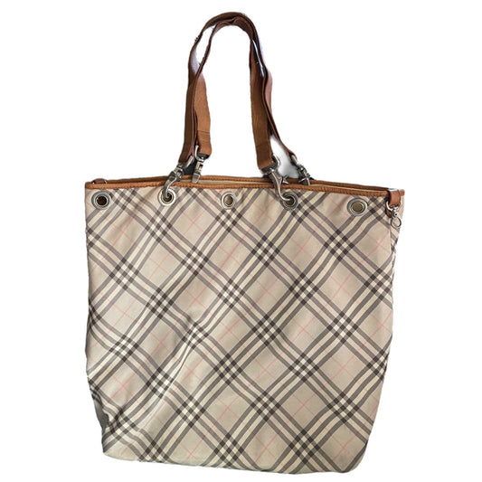 A classic plaid tote bag with a beige, brown, and black check pattern, featuring brown leather shoulder straps and silver-tone metal grommets.