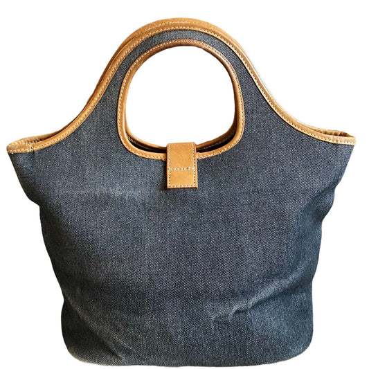 Blue denim handbag with brown leather handles and trim on a white background