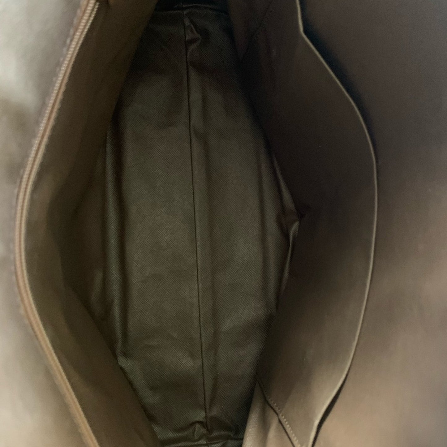 Close-up of a brown leather bag interior with a visible stitching detail.