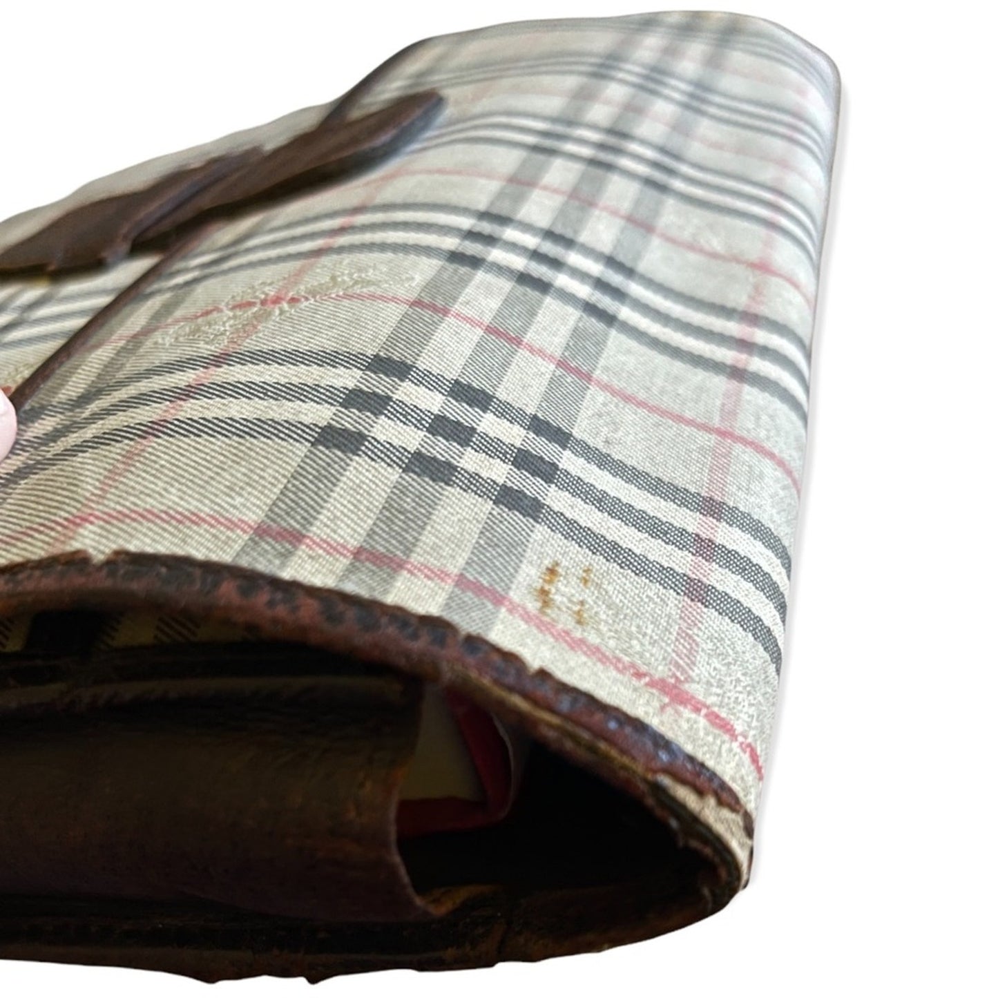 A close-up of a vintage plaid clutch, featuring a beige, black, and red tartan pattern with a dark brown leather trim and strap, set against a plain white background.