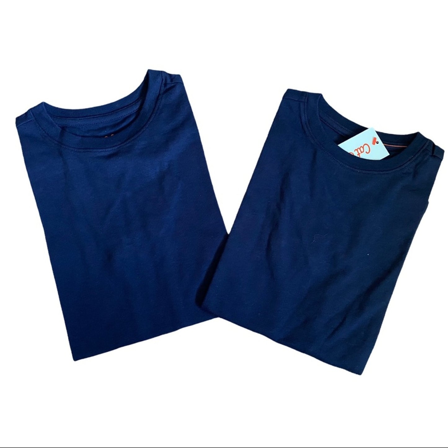 Two folded blue shirts on a white background