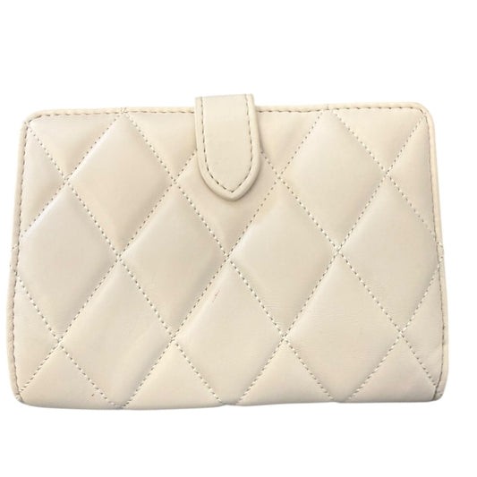 Back of off white quilted wallet on a white background