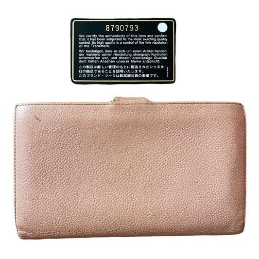 A light pink pebbled leather wallet shown flat against a white background, with a black authenticity card above it.