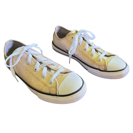 A pair of low-top canvas sneakers with a metallic glitter finish, white laces, and white rubber toe caps and soles, shown on a plain white background.