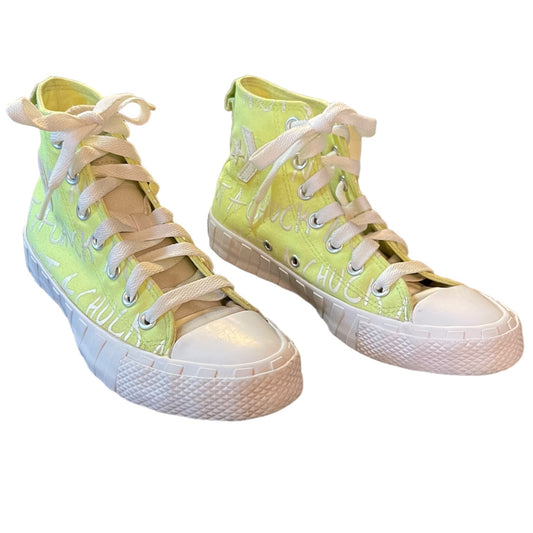 Pair of neon green high-top sneakers with white laces on a white background