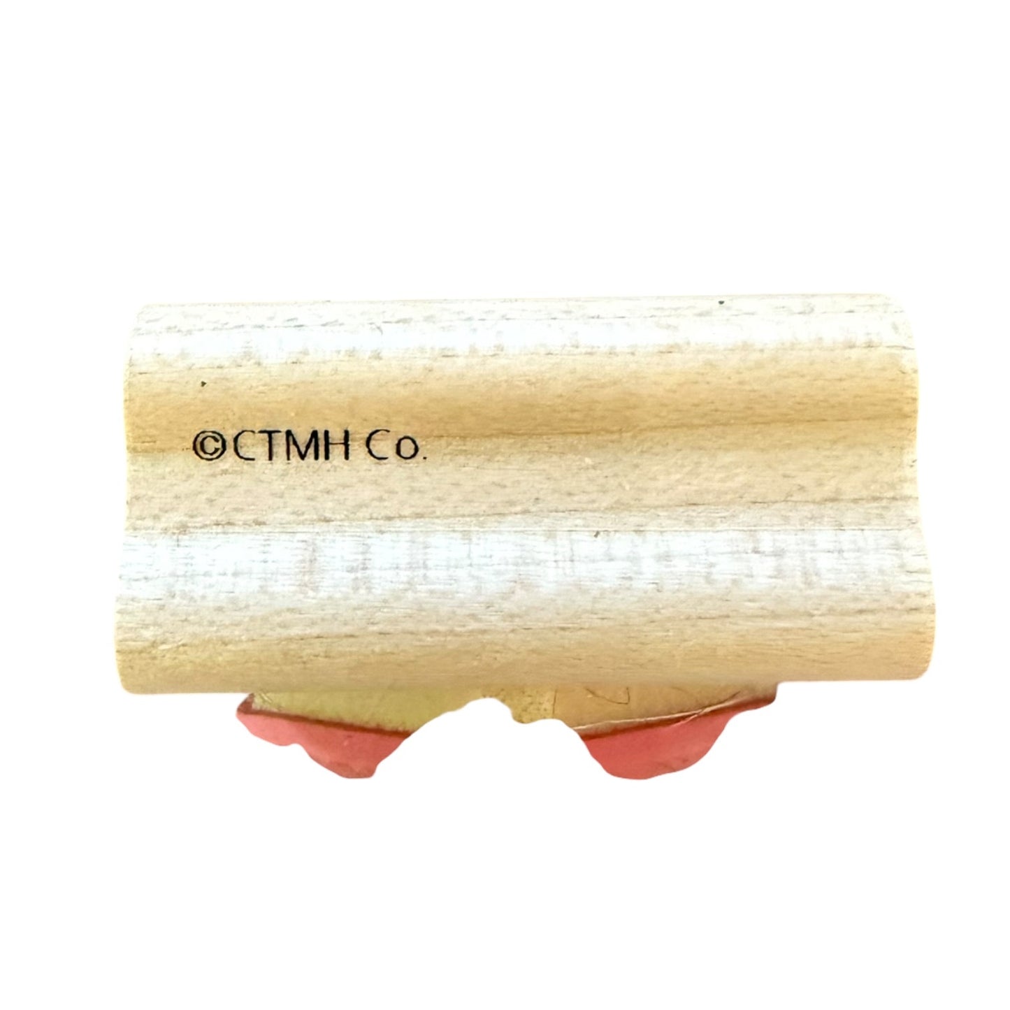 A wooden stamp block featuring the text '©CTMH Co' printed on the side and pinkish-red backing material visible at the bottom, isolated on a white background.