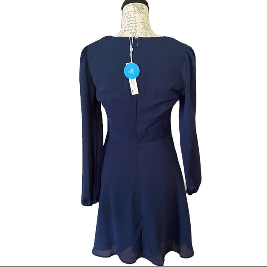 Back of Navy blue dress on a mannequin with a visible tag against a white background