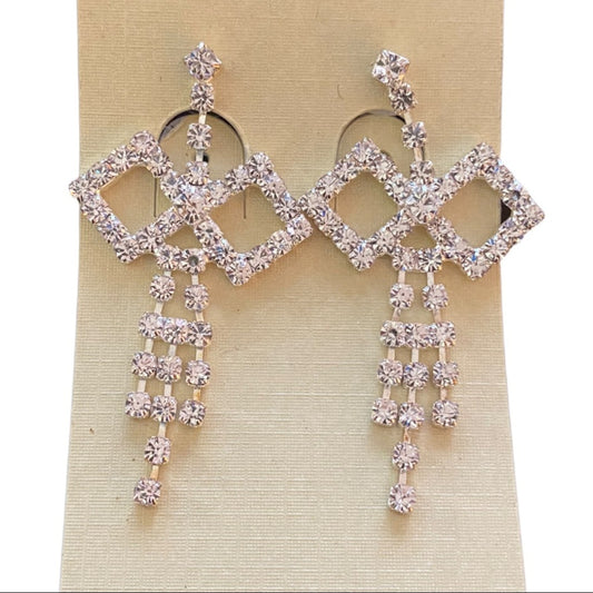 Pair of diamond-shaped earrings with dangling crystals on a beige card.