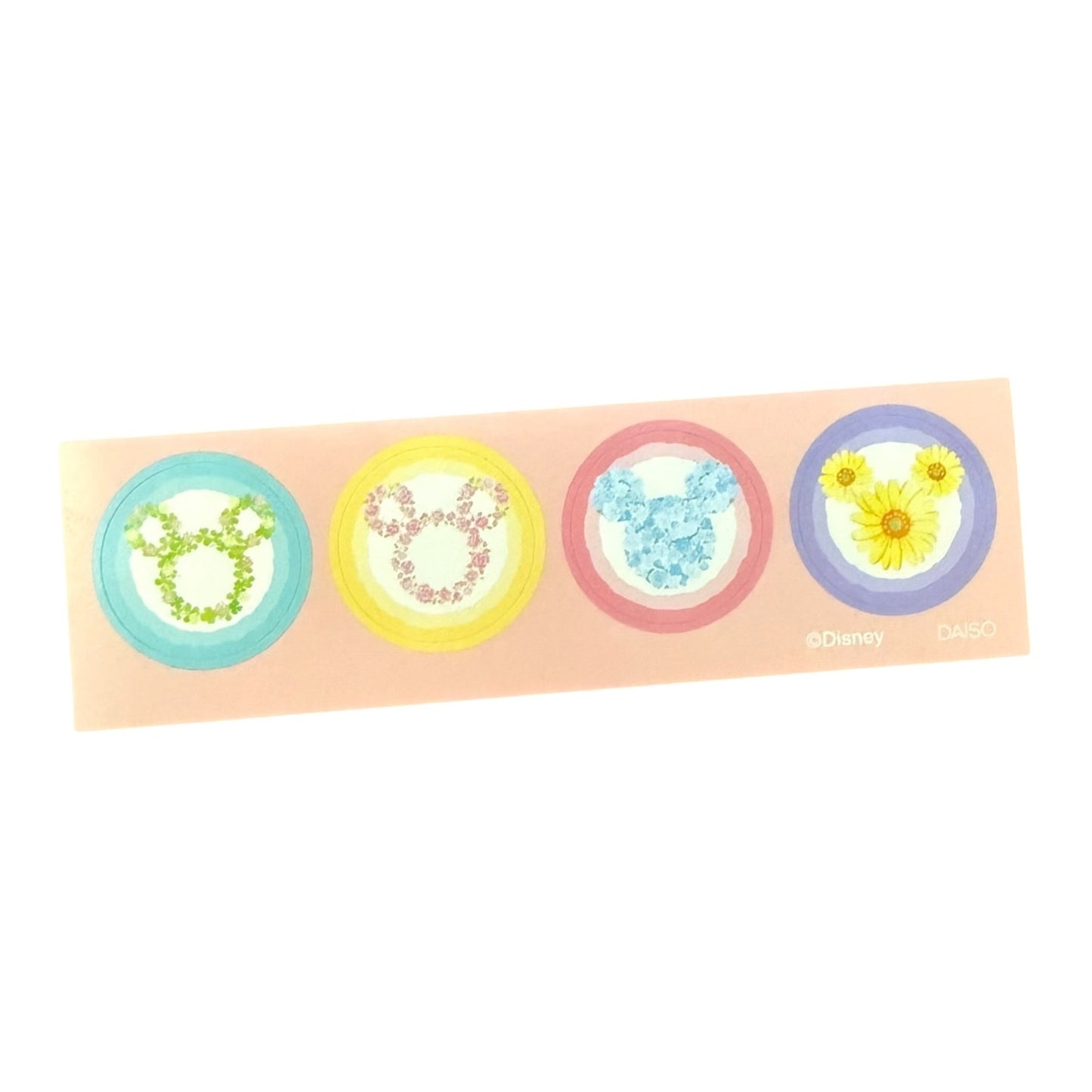 A rectangular sheet of four circular stickers featuring Disney character and flower motifs in pastel colors: a green Mickey-style silhouette, a pink Mickey-style silhouette, a blue Mickey-style silhouette, and yellow flowers on a purple circle.
