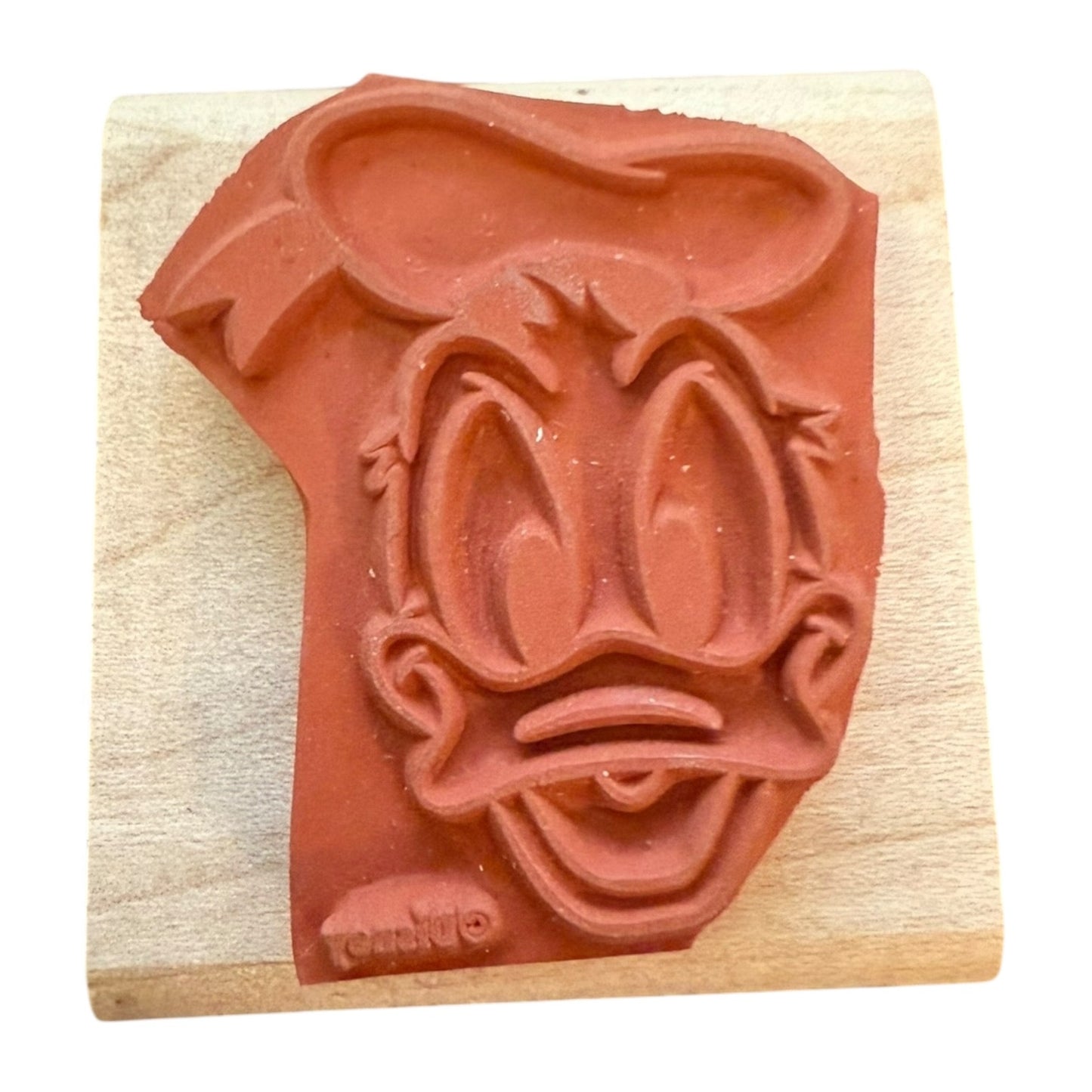 Rubber stamp with a cartoon character's face on a wooden block