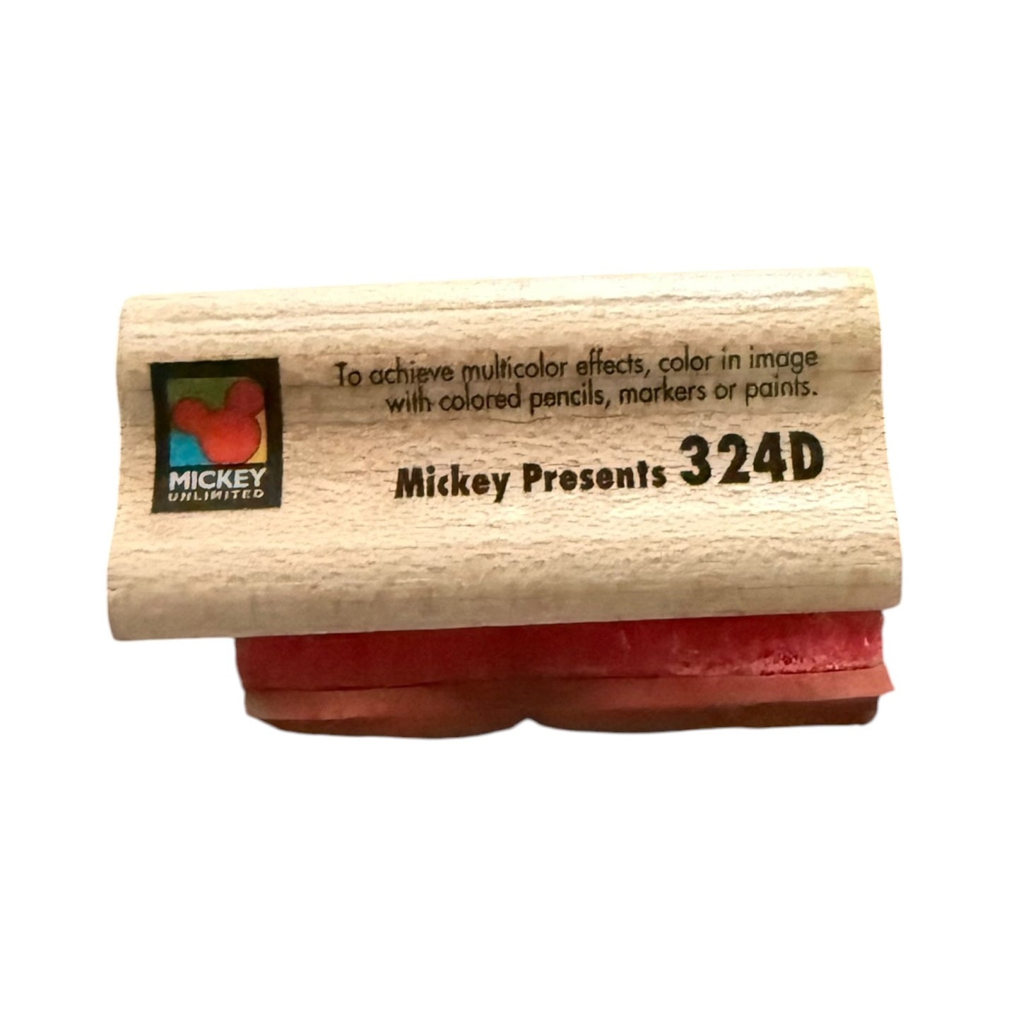 Wooden stamp with red pad and 'Mickey Unlimited' branding on a white background
