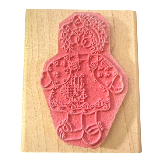 Decorative red stamp with a doll on a wooden block