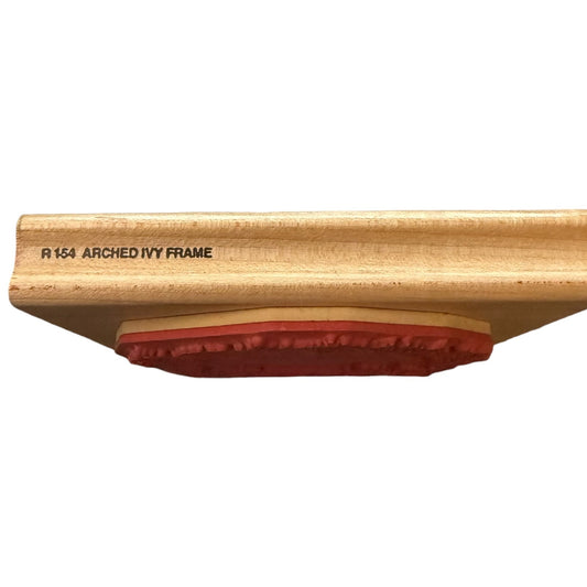 Close-up of a light natural wood rubber stamp with black printed text reading 'R 1514 ARCHED IVY FRAME', set against a plain white background.