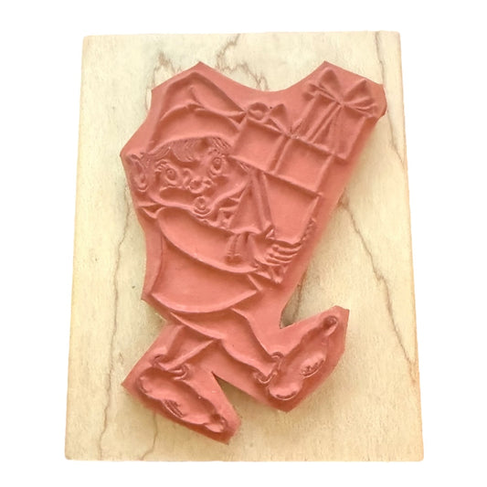 A terracotta-colored rubber stamp light beige wood block against a white background.