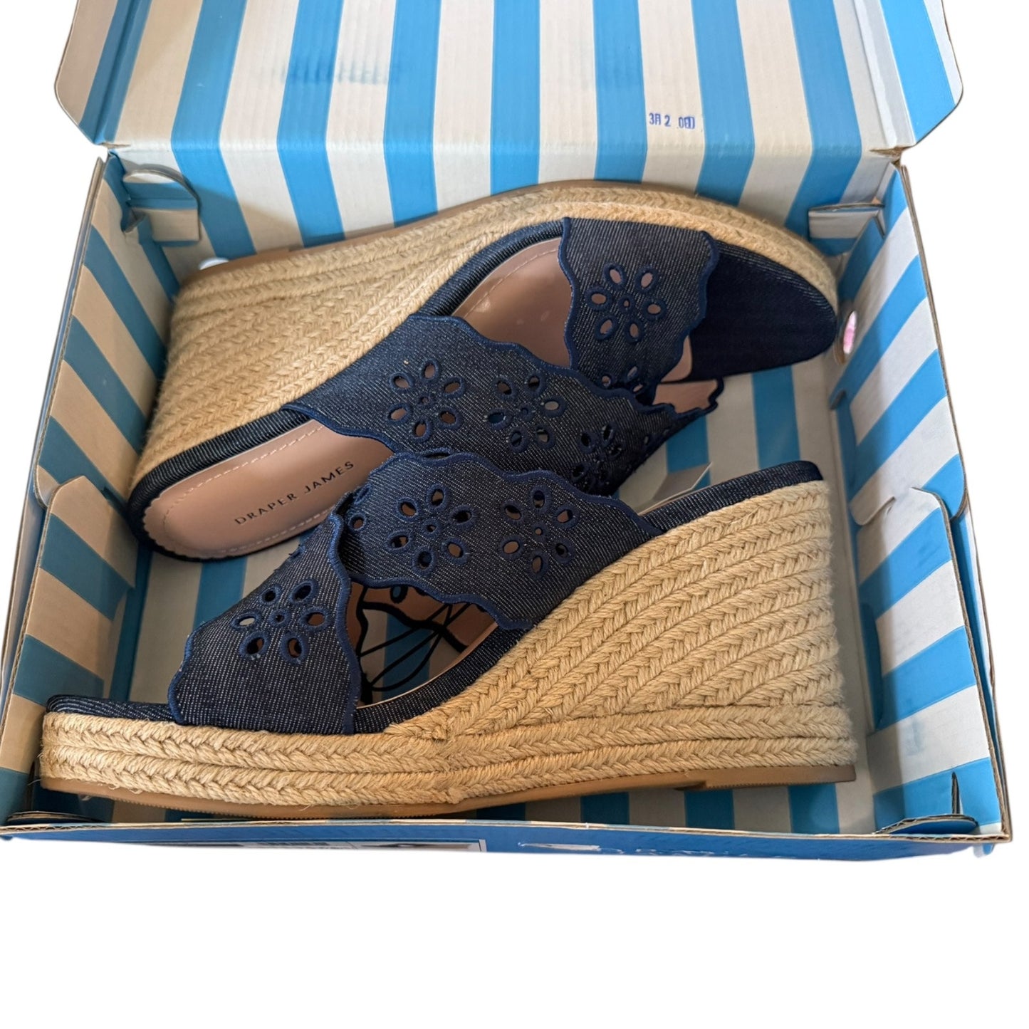 Navy wedge sandals with woven sole in a striped shoe box