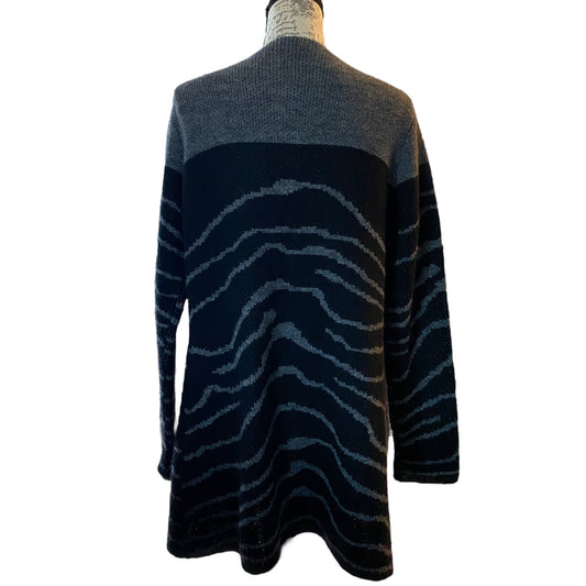 A long-sleeve knit sweater shown from the back on a mannequin, featuring a color-blocked design with a dark gray upper and black & gray lower body with a wavy zebra-like stripe pattern.