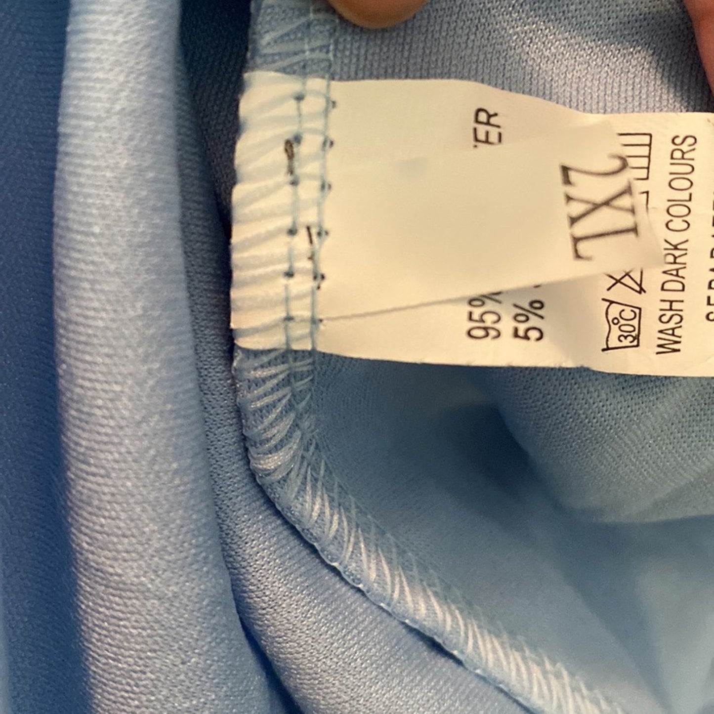 Close-up of a blue fabric with a label showing garment information.
