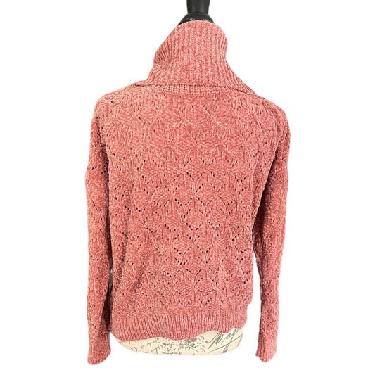 A textured knit turtleneck sweater in a dusty rose or terracotta pink color, displayed on a black mannequin torso against a plain white background.