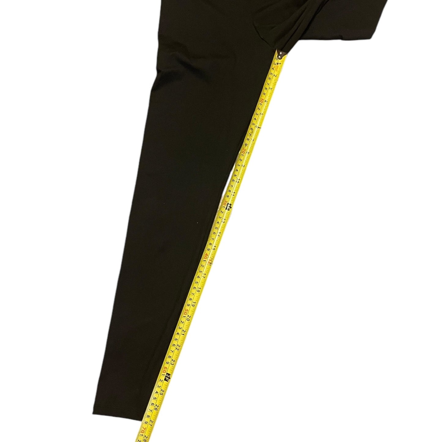 Black pants with a yellow measuring tape on a white background
