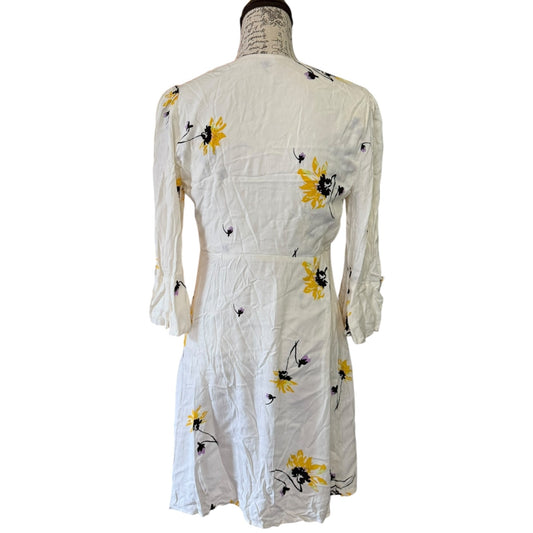 A long-sleeve dress with a yellow and black sunflower print, displayed on a dress form mannequin against a white background.