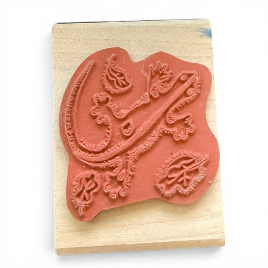 Decorative rubber stamp with intricate design on a wooden block