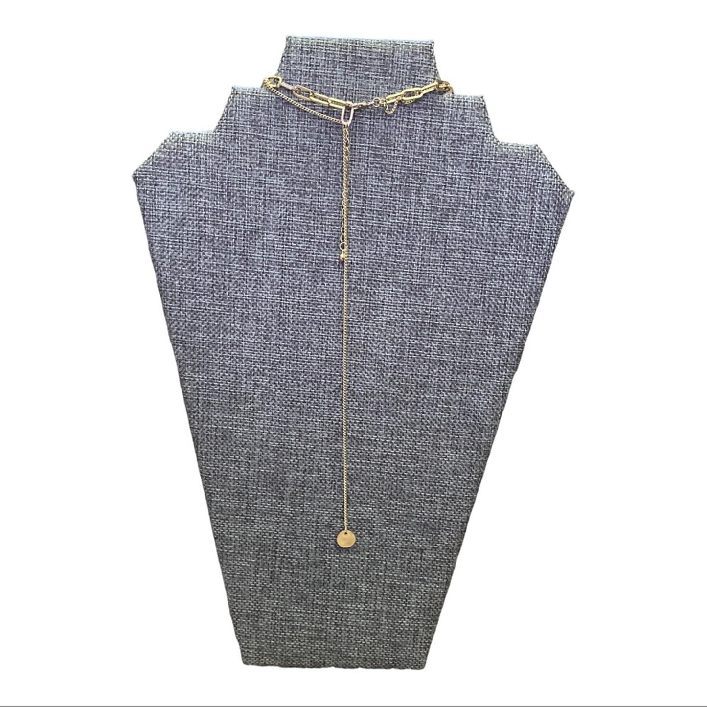 Gold necklace on a gray mannequin bust with a white background
