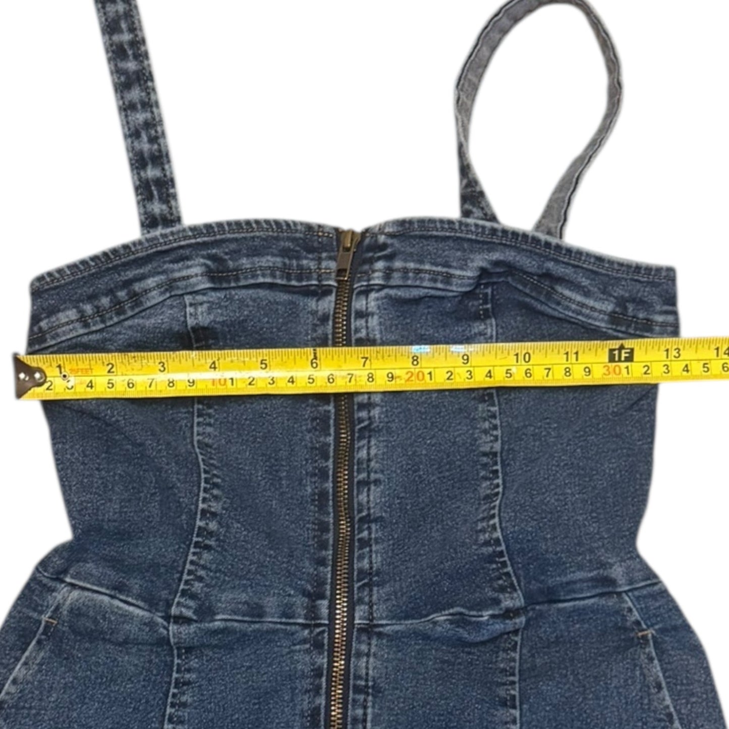 Blue denim dress with suspenders and a measuring tape indicating size.