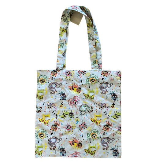 A fabric tote bag with a white background covered in a colorful, monsters, and abstract doodles, featuring two shoulder straps.