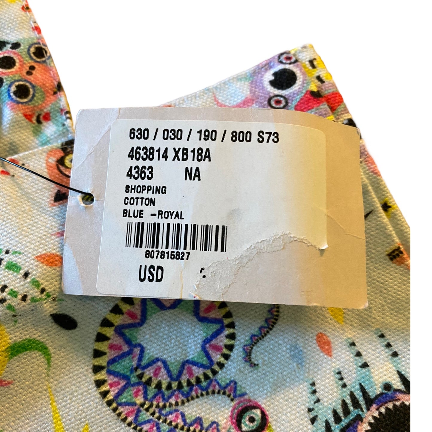 A close-up of a colorful printed fabric and tag attached to a white paper size and price label, showing the text '630 / 030 / 190 / 800 $73' and 'BLUE - ROYAL' on a white background.
