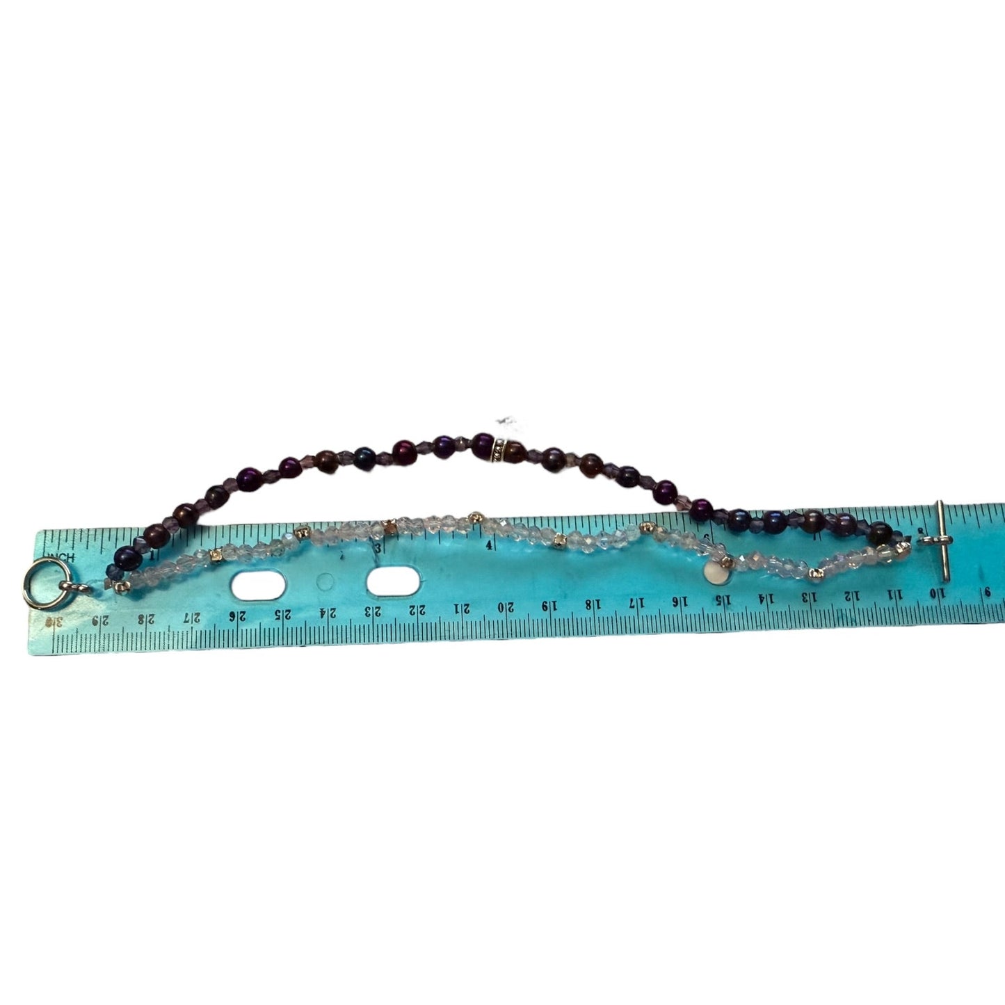 A beaded bracelet, shown on a light blue measuring ruler against a white background.