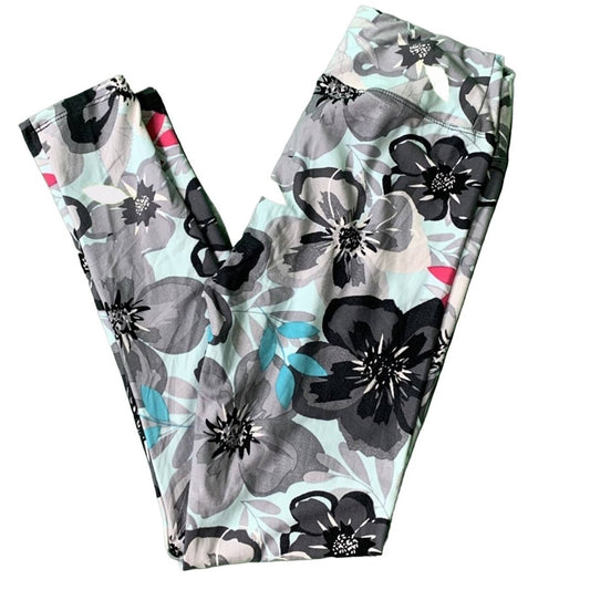 A pair of high-waisted leggings with a floral print, featuring large black and gray flowers on a light mint green background with small teal and pink accents.