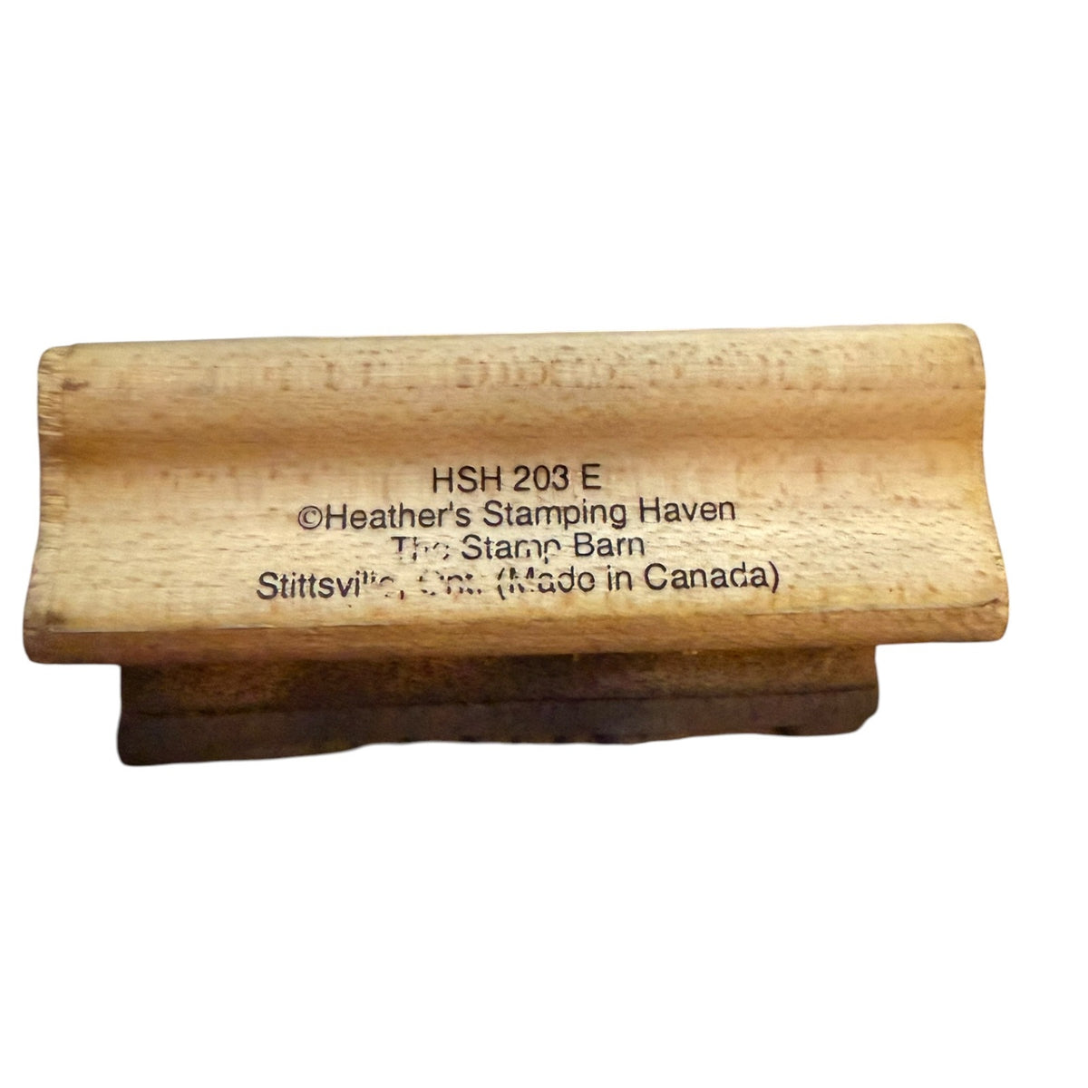 A wooden stamp block with a dark brown rubber stamp face, featuring text on the wooden block. The text reads 'HSH 203 E', '©Heather's Stamping Haven', 'The Stann Barn', 'Stittsville, Ont.