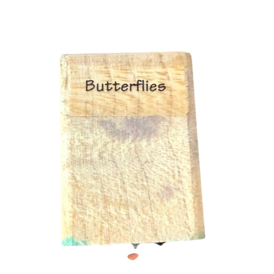 Wooden block with 'Butterflies' text on a white background