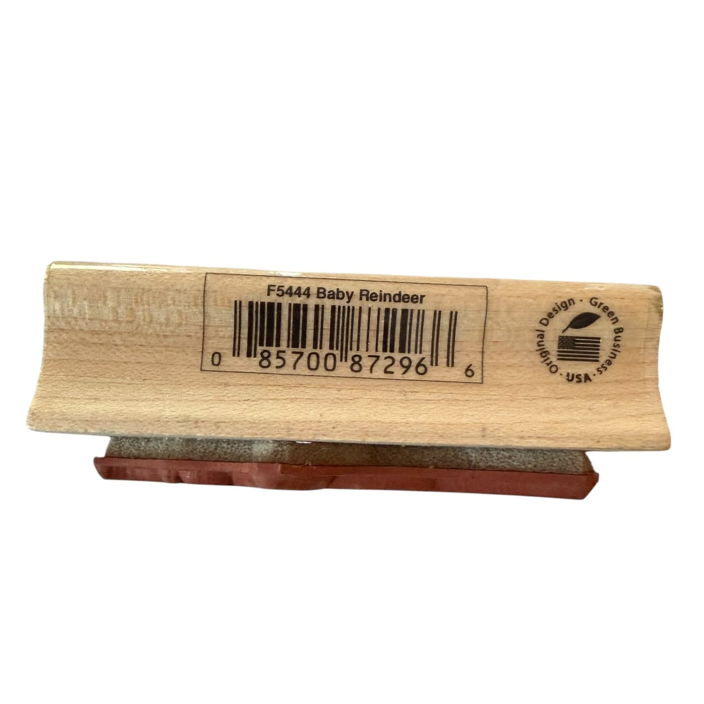 A wooden stamp block with a baby reindeer design, featuring a barcode and the text 'F5444 Baby Reindeer' on the top, resting on a reddish-brown base against a white background.