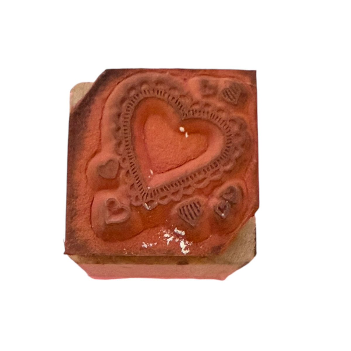 Heart rubber stamp showing stain on a wood block with a white background.
